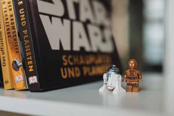 Kleine Star Wars Figuren in einem Regal vor einem Star Wars Buch