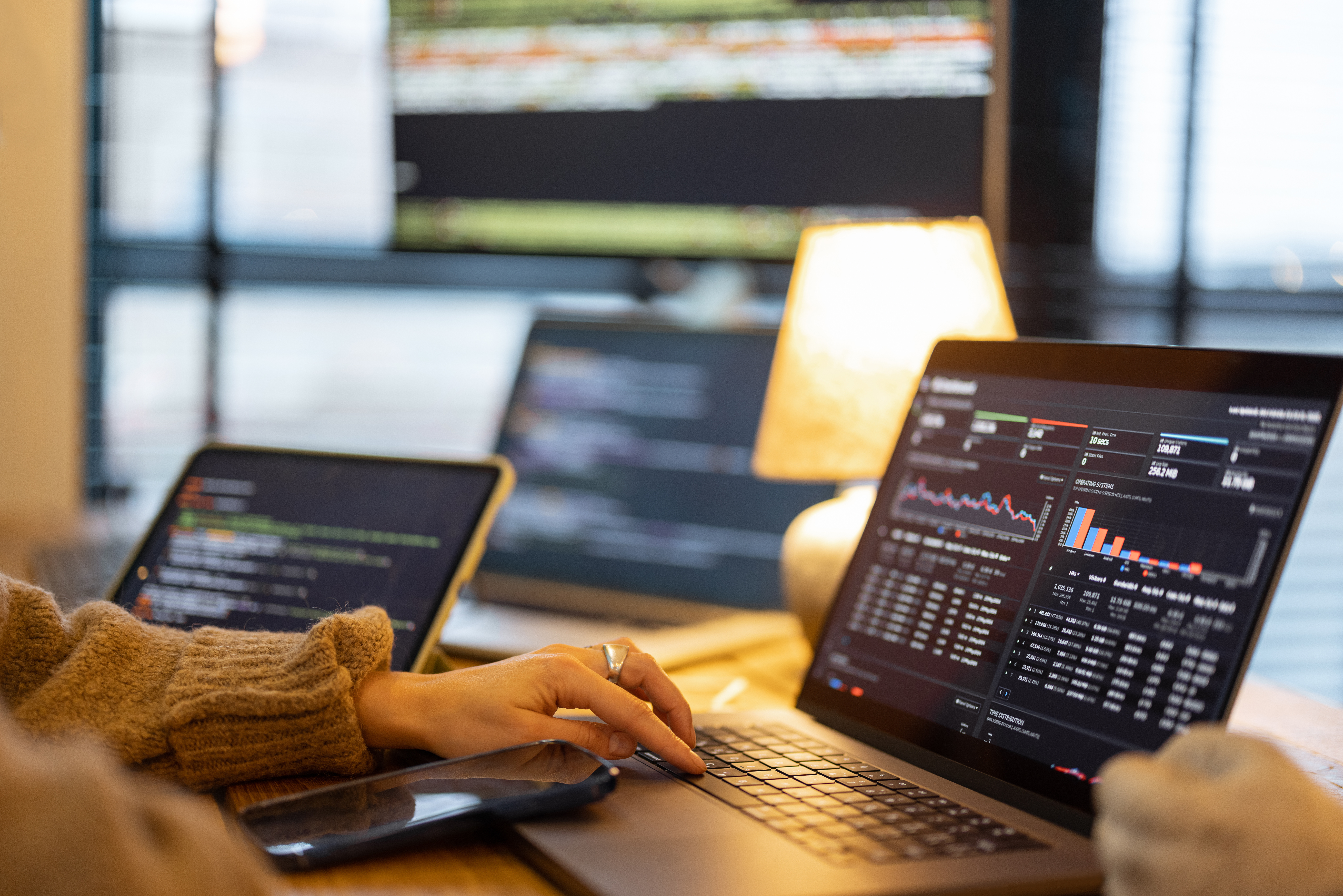 Ein Mitarbeiter oder eine Mitarbeiterin vor einem geöffneten Laptop
