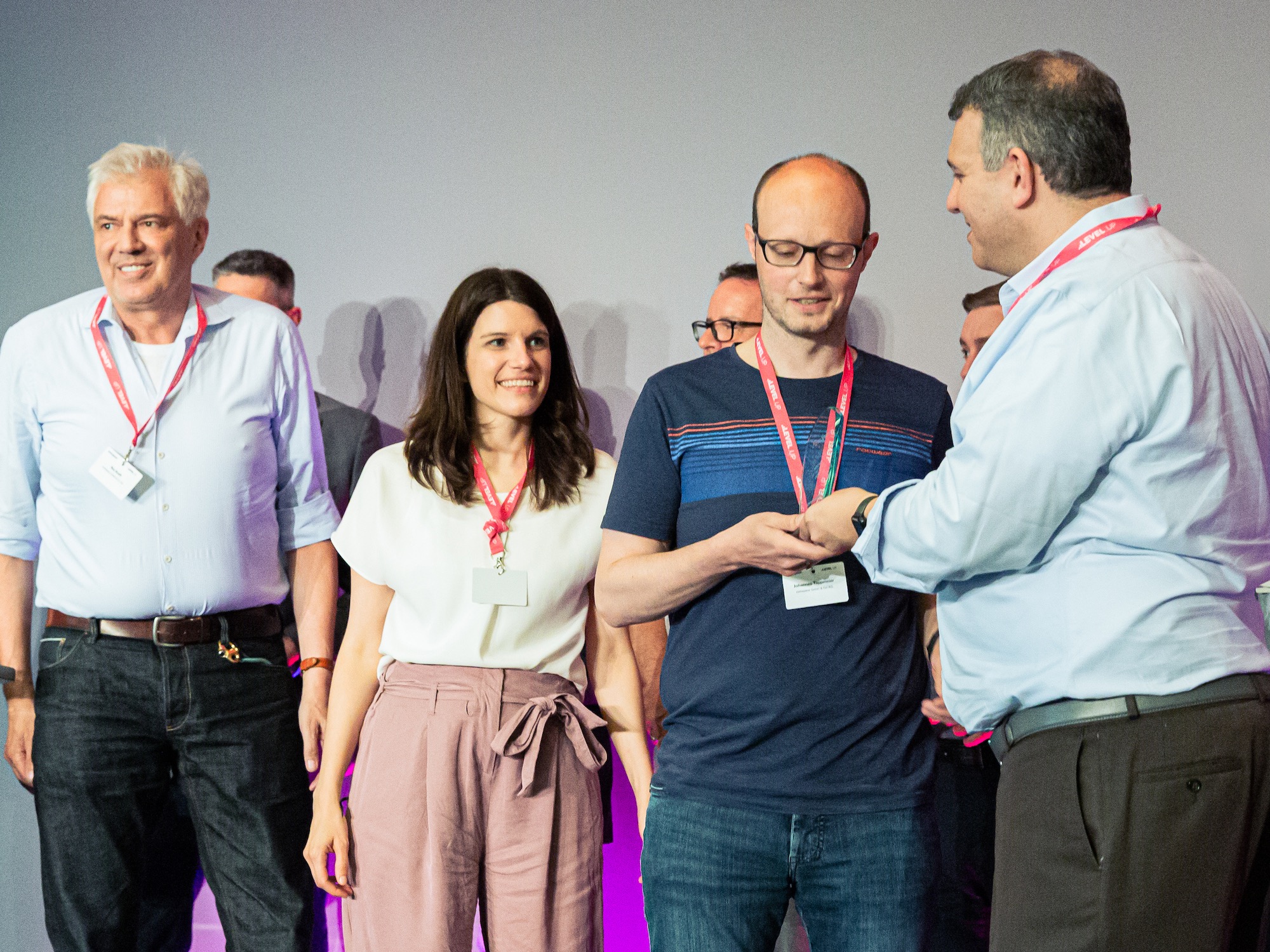 Roy Kraft, Eva Stock und Johannes Tappmeier von comspace nehmen den Award von Jonah Paransky, CEO von Crownpeak entgegen.